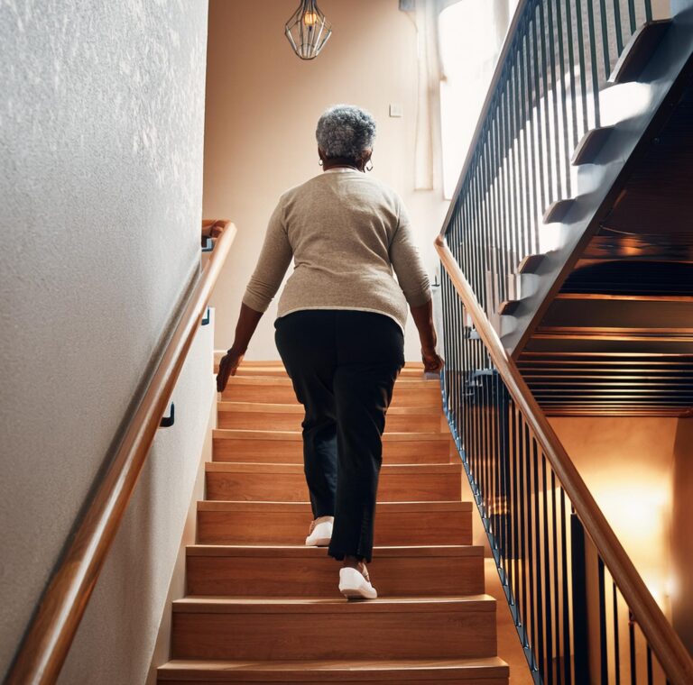 an aged woman climbing stair